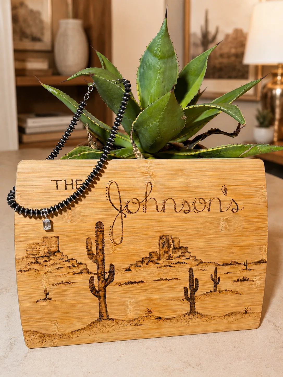 Necklace displayed with an agave plant and western engraved board